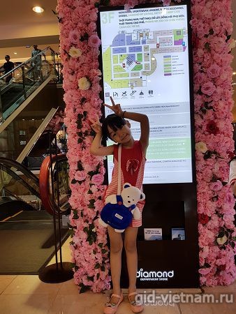 Девочка на фоне информационного стенда торгового центра