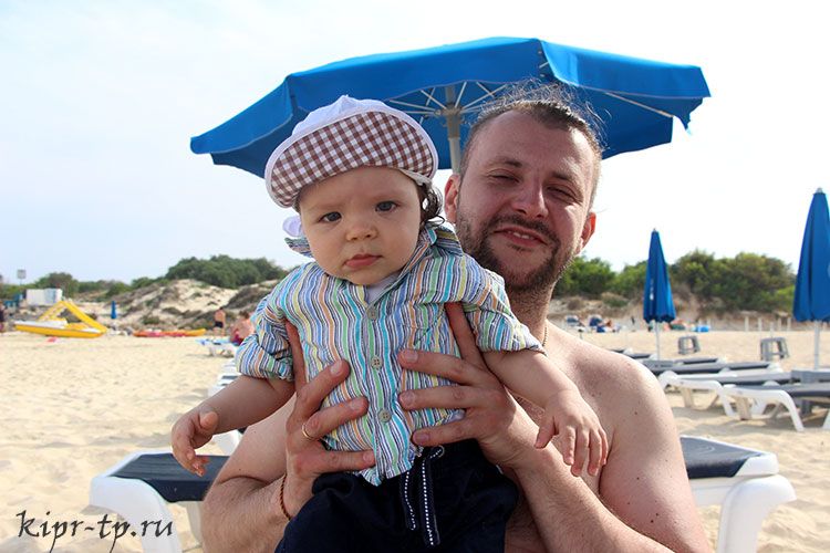 Мы с ребёнком под зонтом на пляже в Айя-Напе
