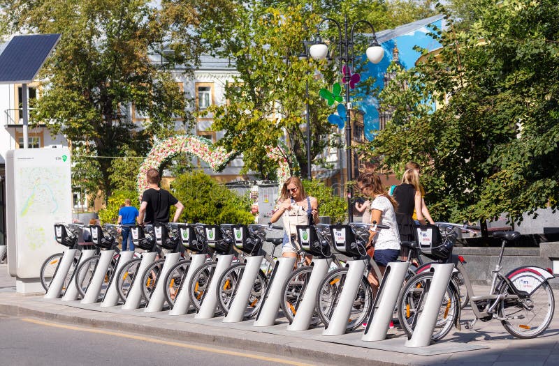 Young people at bicycle rental station on Pyatnitskaya street in royalty free stock image